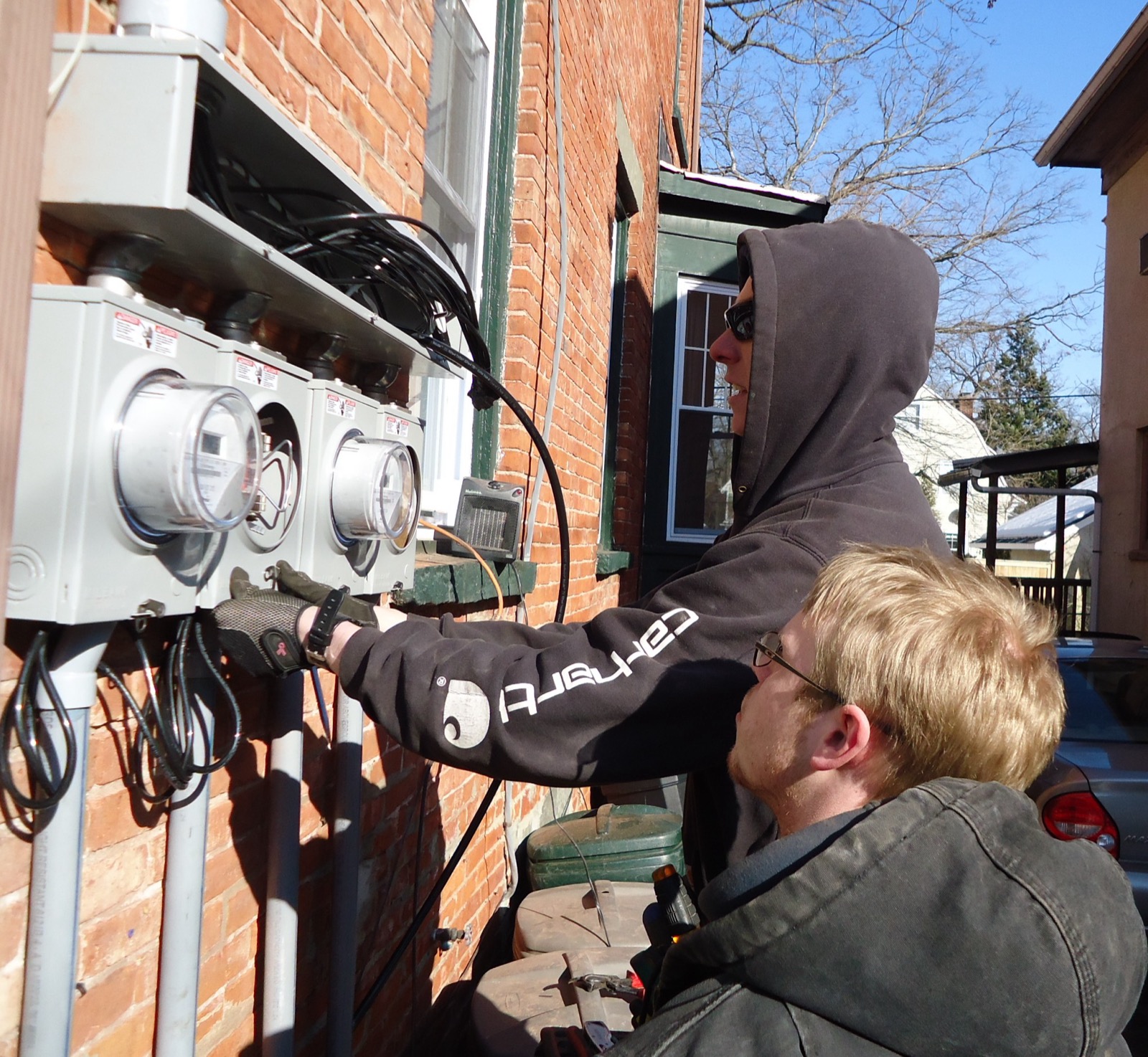 Two licensed electricians installing an electrical panel in a Cape Coral home